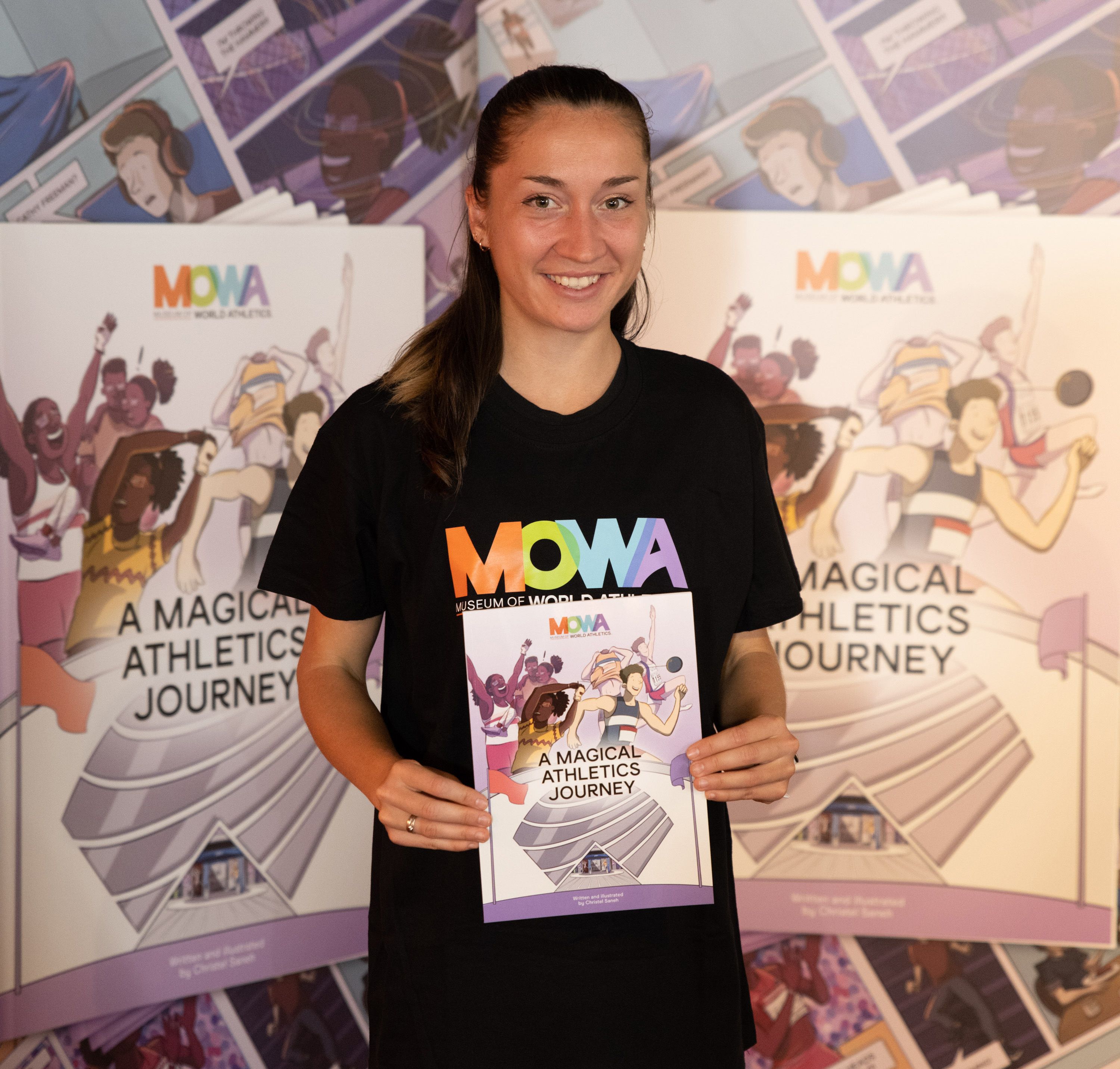 Lili Anna Vindics-Toth with a copy of A Magical Athletics Journey