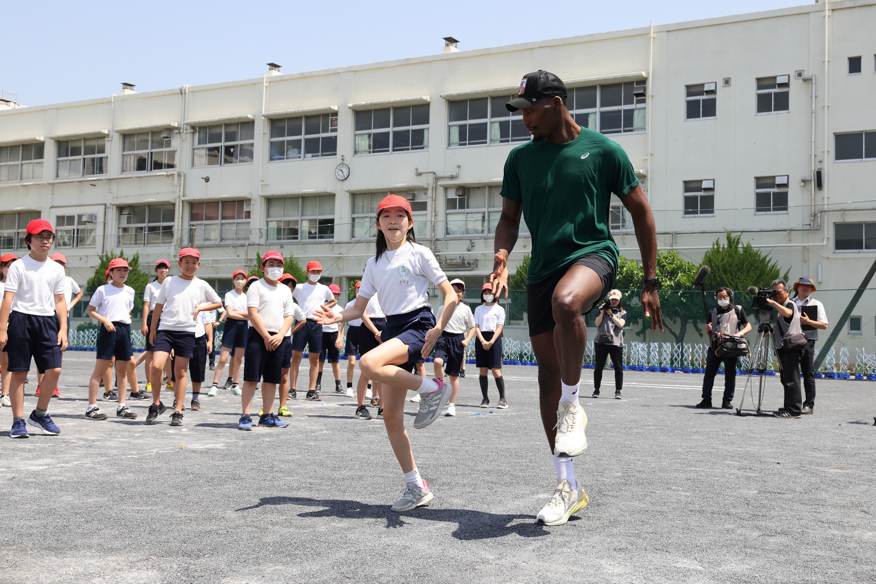 Fred Kerley demonstrates some sprint drills at the Otsuna Elementary School in Yokohama