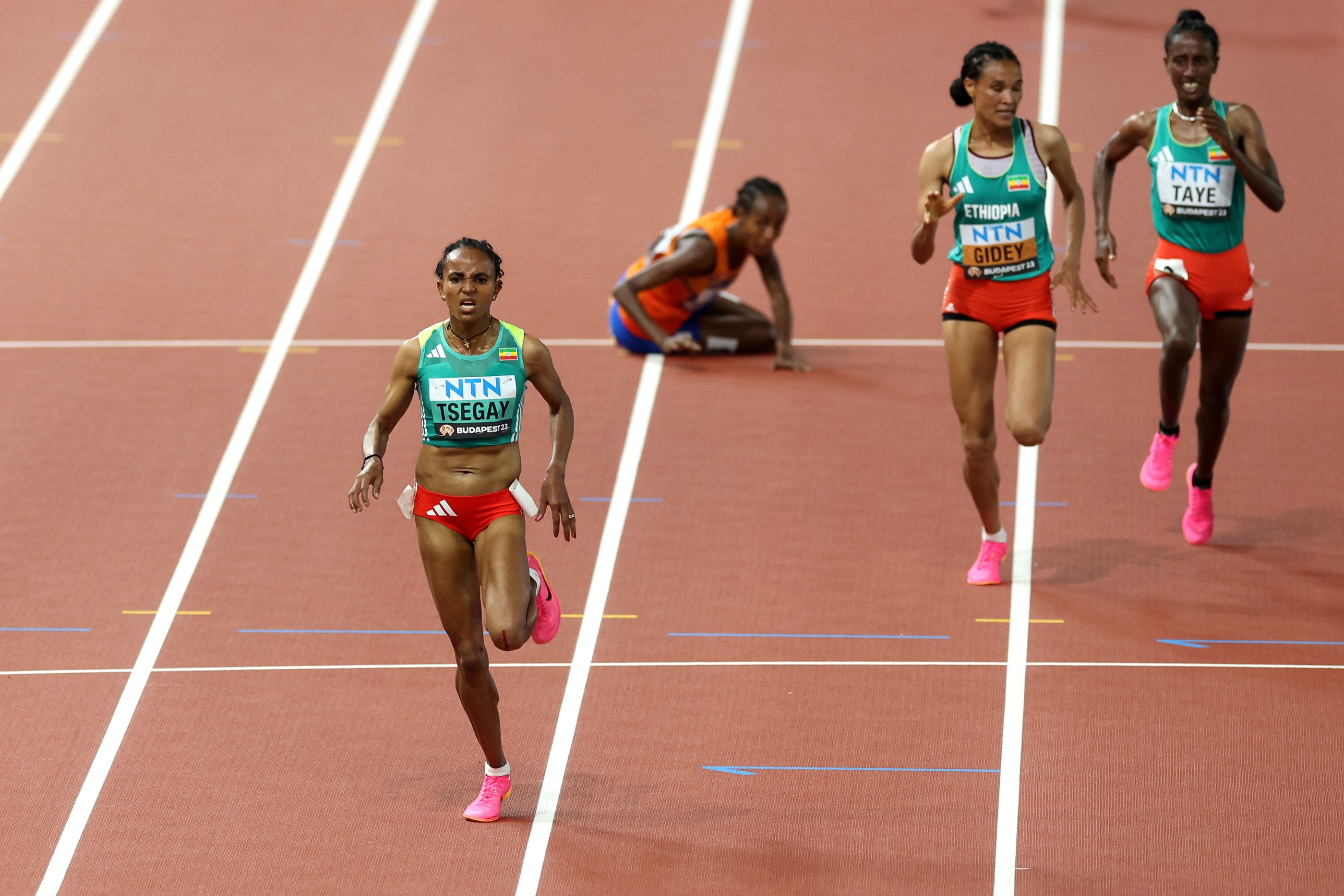 Gudaf Tsegay on her way to the world 10,000m title as a fallen Sifan Hassan looks on in Budapest