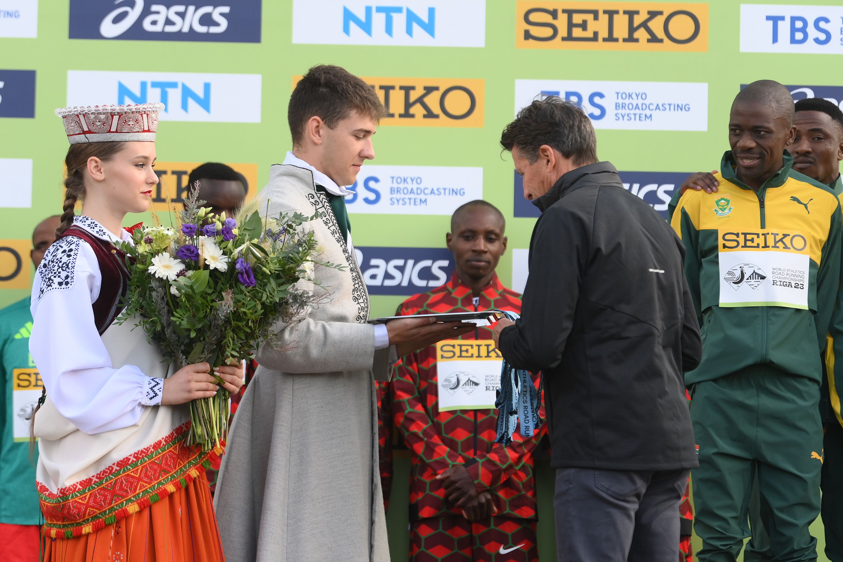 Stephen Mokoka prepares to receive his world half marathon team medal from Sebastian Coe in Riga