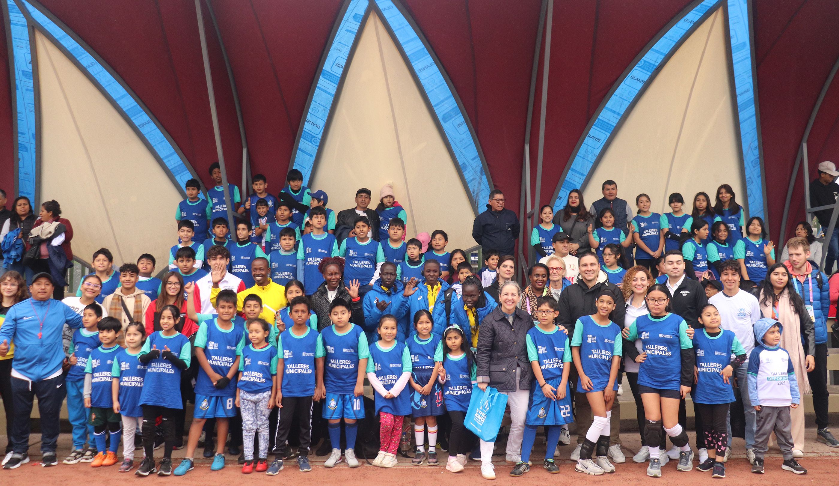 Members of the Athlete Refugee Team with local children and Laura Almirall of UNHCR in Lima