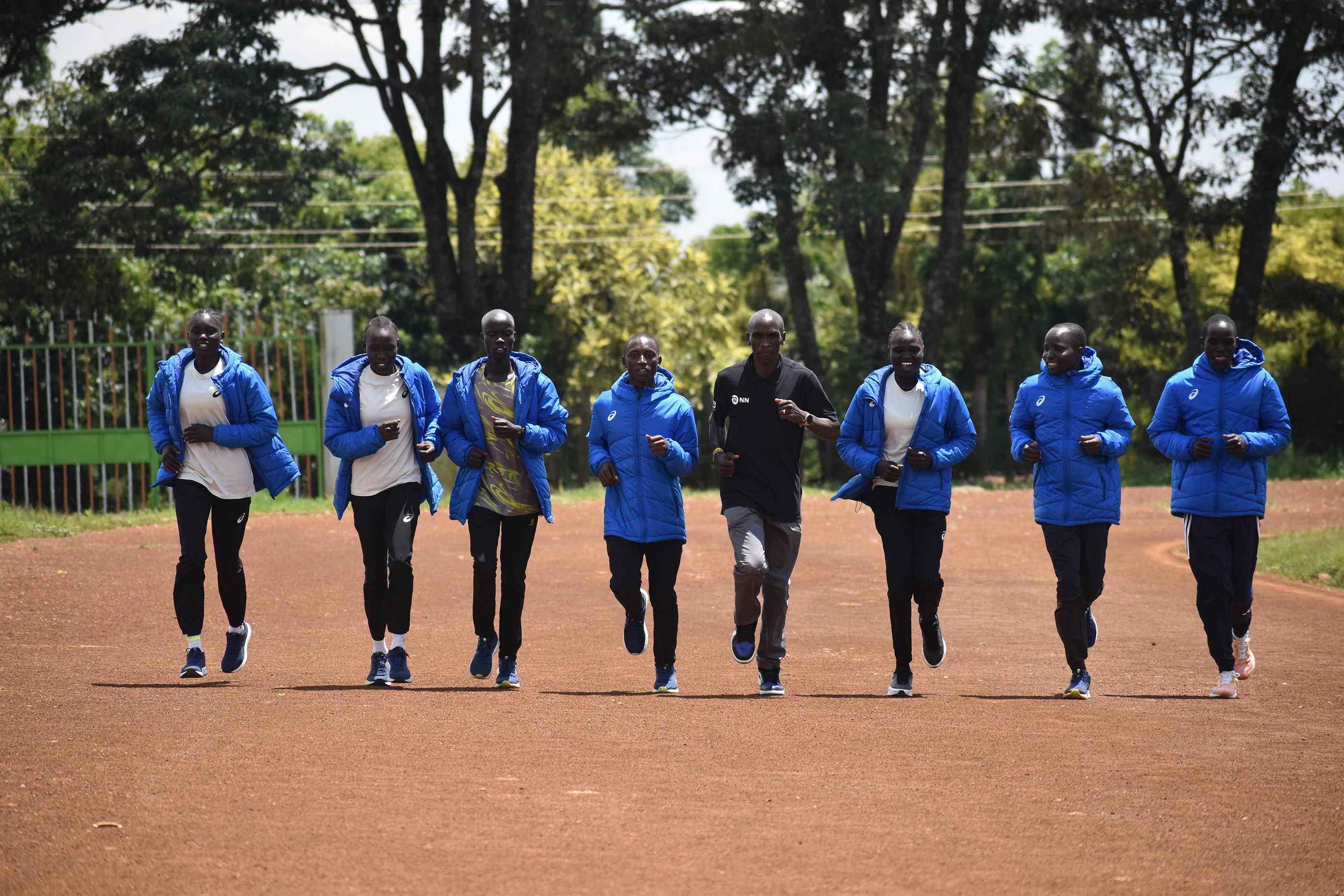 Mentor Eliud Kipchoge runs alongside members of the refugee athletics team