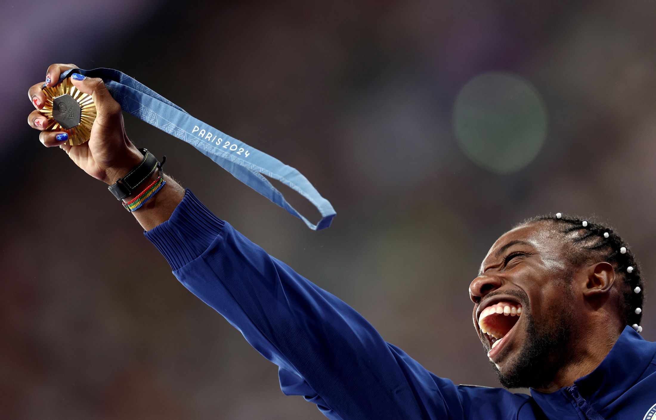 Noah Lyles celebrates with his 100m gold medal during the medal ceremony at the Paris 2024 Olympic Games