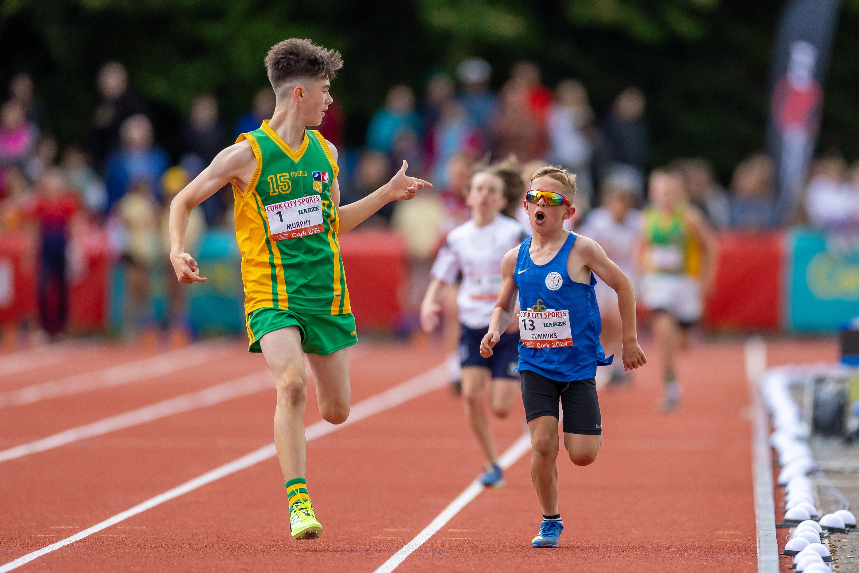 Tommy Murphy gestures to Charlie Cummins during the primary boys mile race at the 2024 Cork City Sports athletics meet