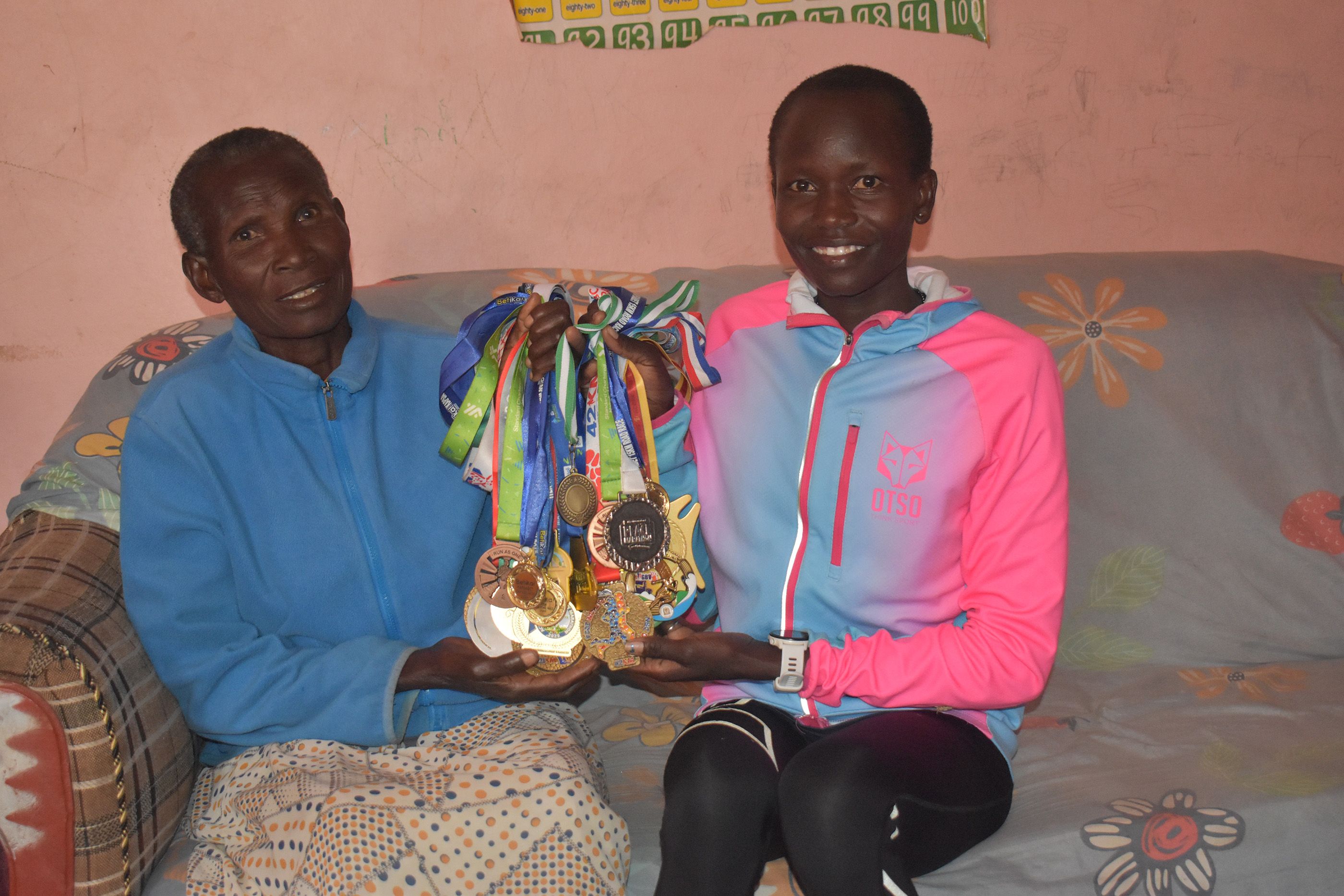 Atalena Napule Gaspore Loliha with her mother Veronica Nakivu and medals, including her African Games gold