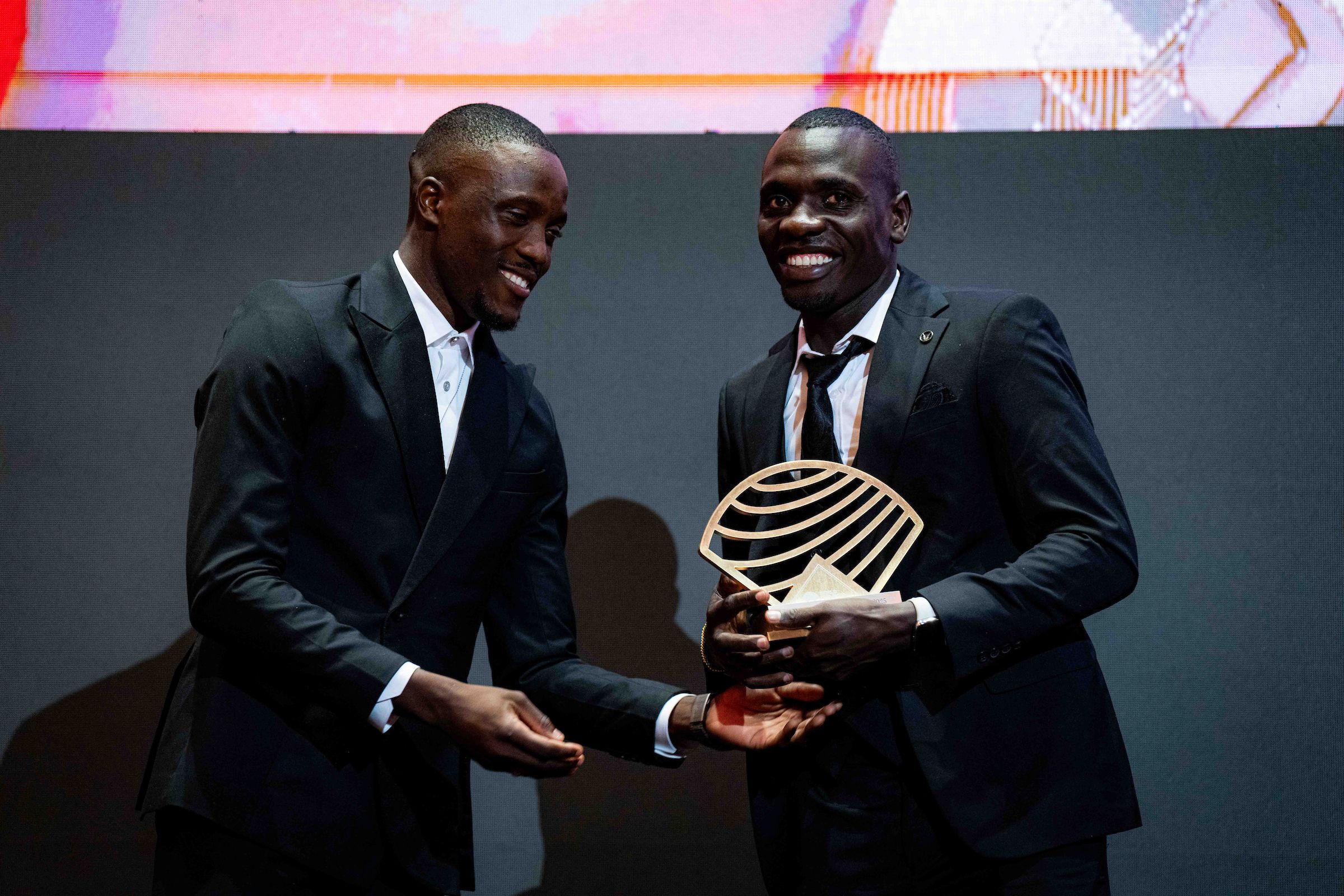 Emmanuel Wanyonyi receives his trophy from Letsile Tebogo at the World Athletics Awards 2025