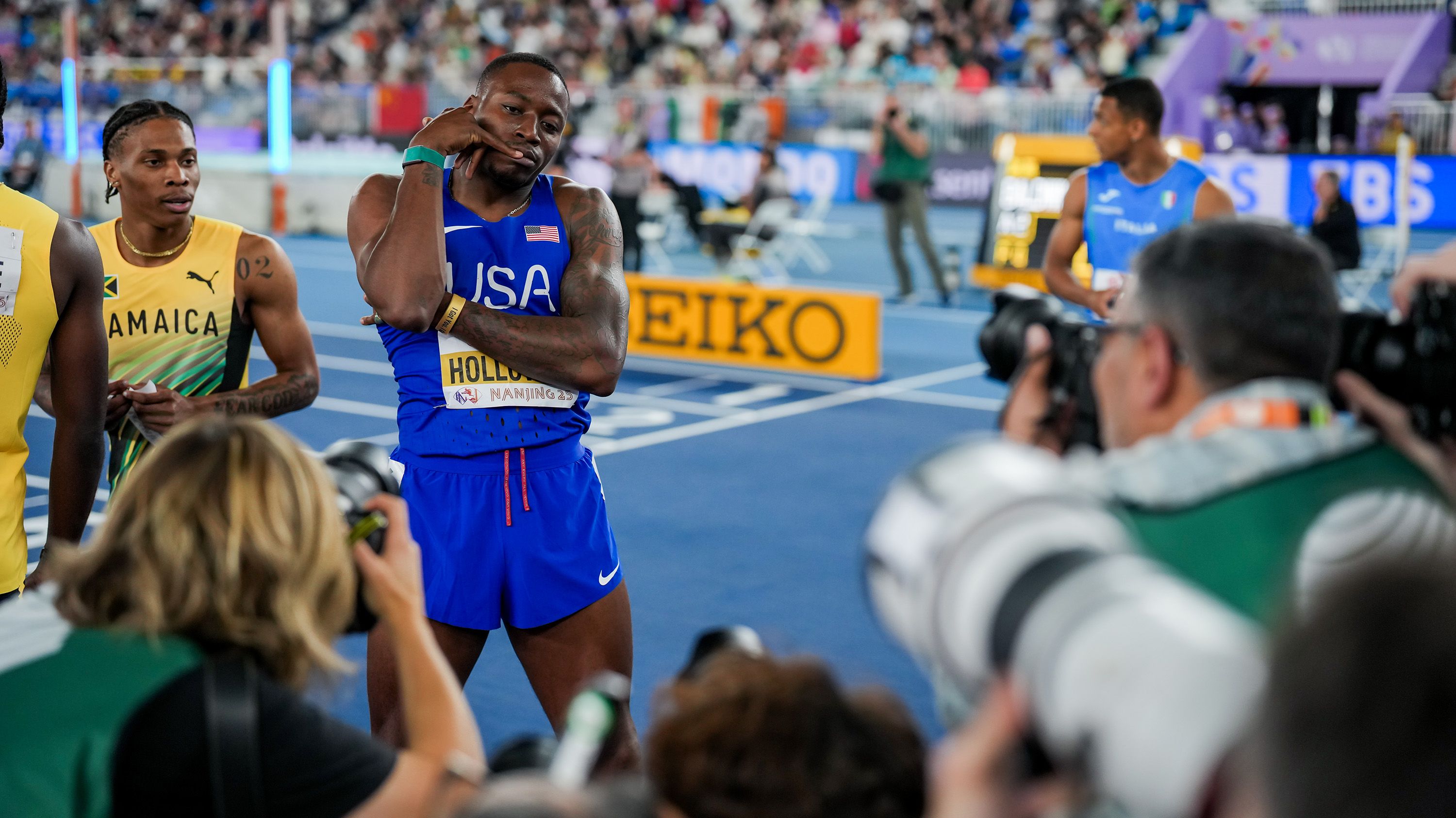 Grant Holloway poses in front of photographers